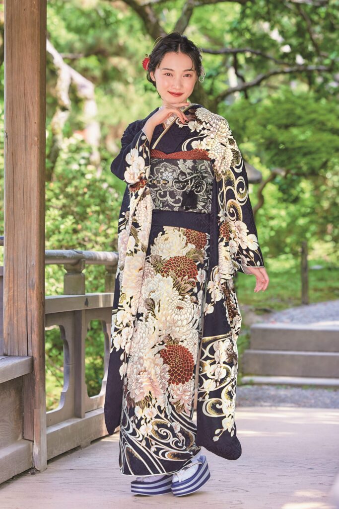 菊の金彩と赤の挿し色が象徴的な紺地振袖